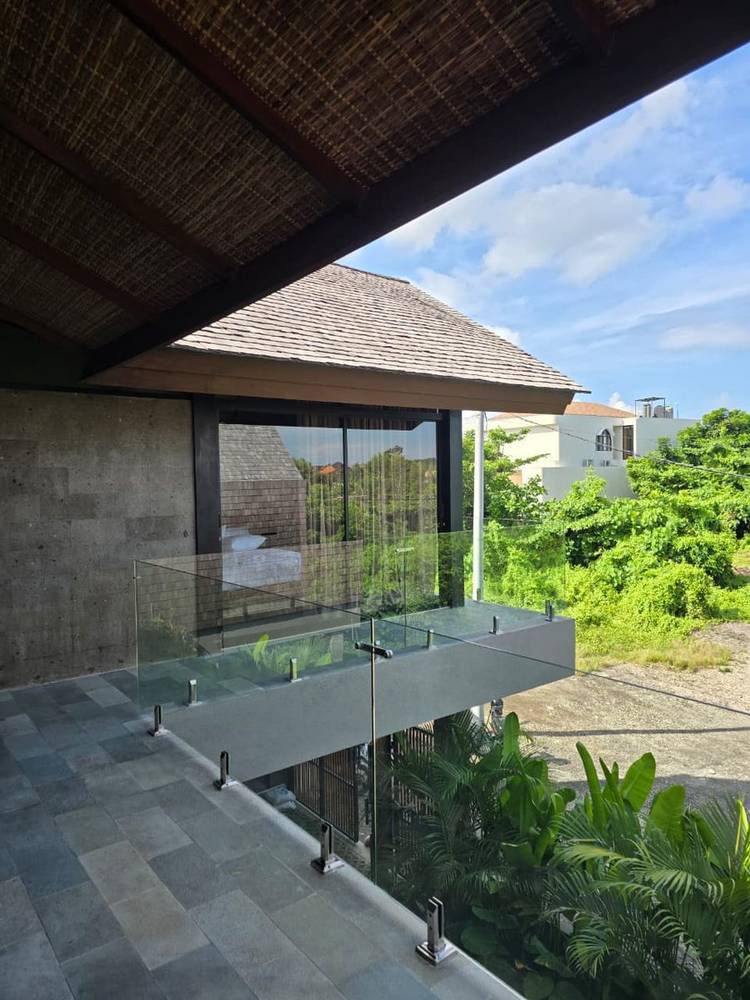 Villa Bali dengan railing kaca frameless dan taman tropis